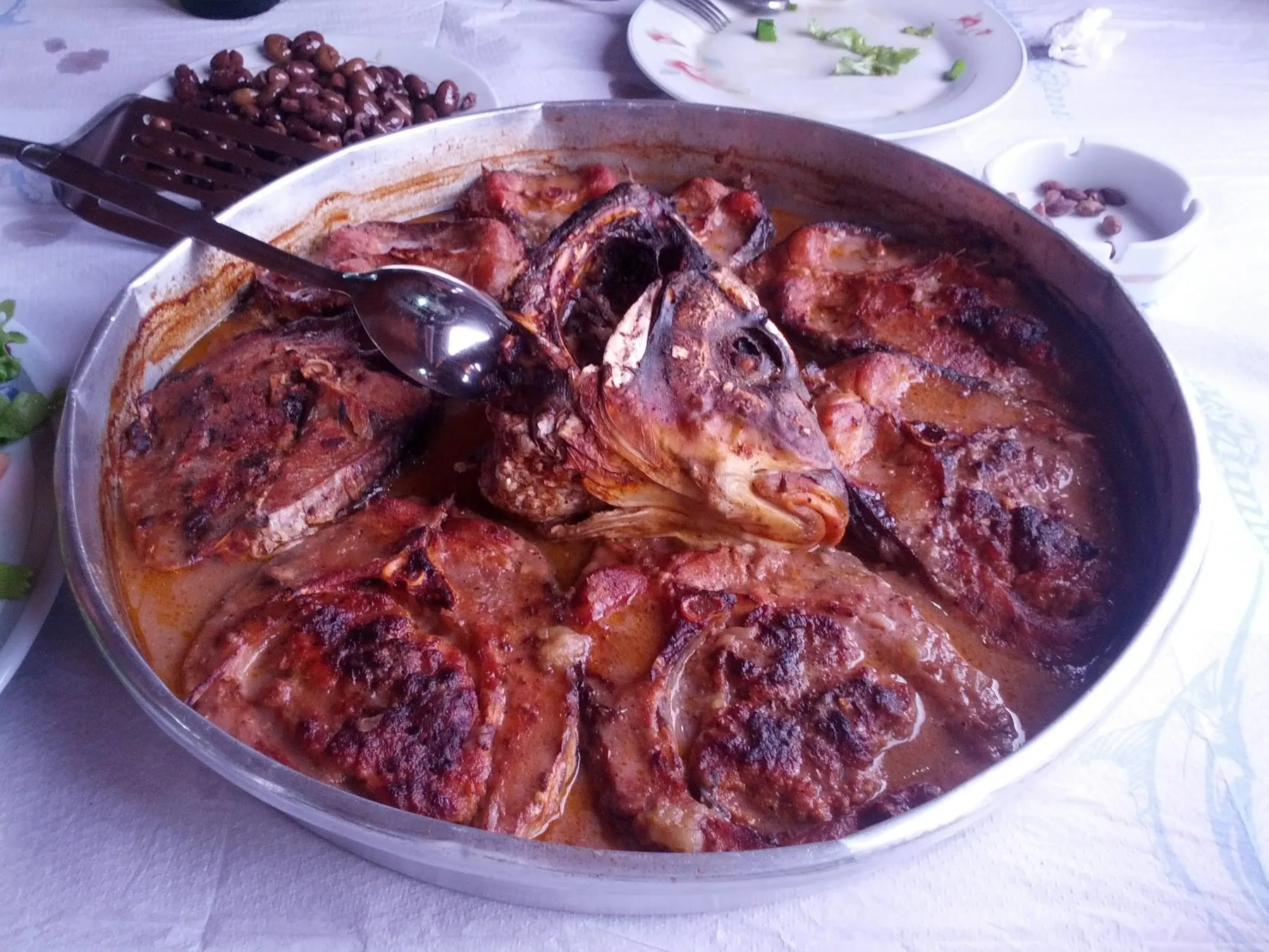 Ugnsbakad karp i tomatsås i en rund form, en traditionell rätt från Shkodra