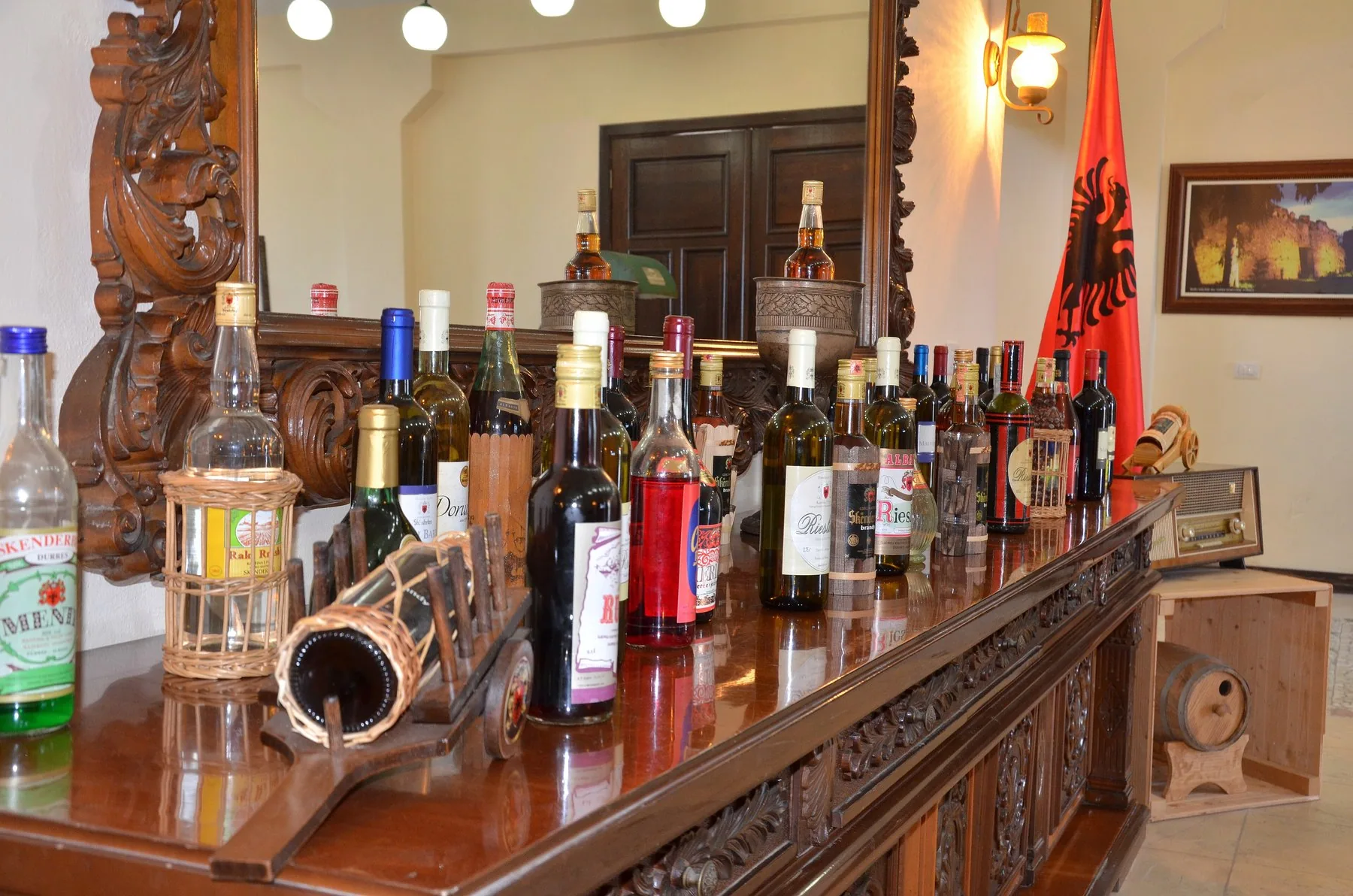 Flaskor med raki, vin och likör uppställda på en träbänk i en albansk dryckesfabrik
