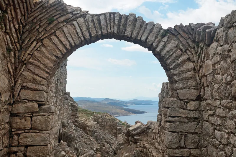 Ett raserat stenvalv i klostret De fyrtio heliga ovanför Saranda ramar in kusten och havet nedanför