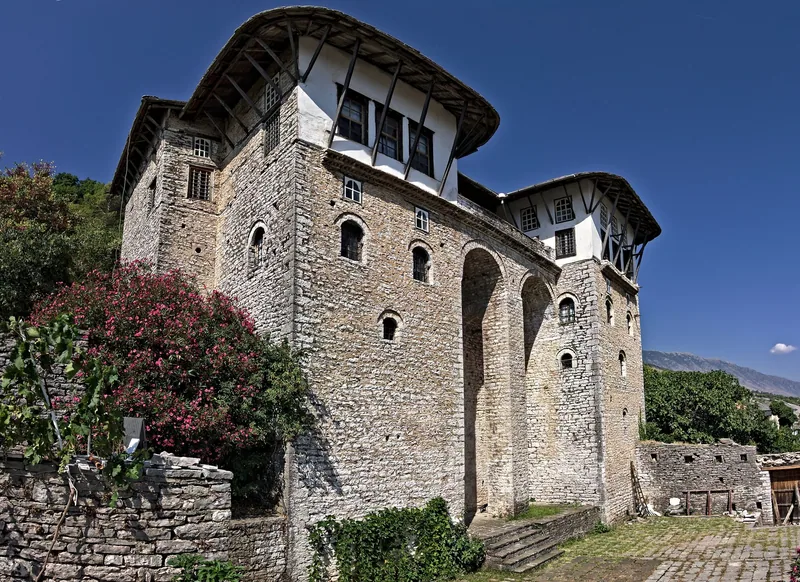 Zekatehuset i Gjirokastra, ett högt tornhus i sten med små fönster nedtill och vitputsad övervåning under skifferbeklätt tak